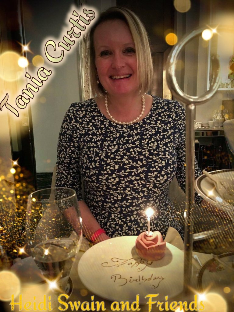 Tania Curtis, sitting at a table with a birthday cake and a glass of wine